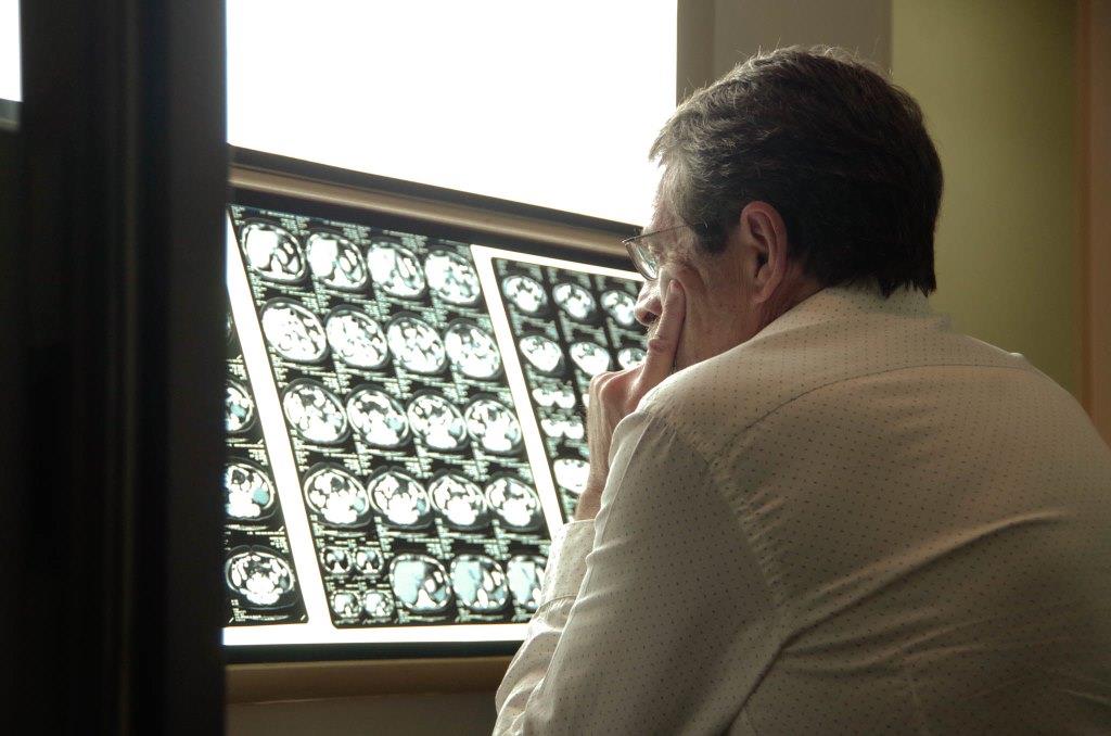 Médico realizando evaluación médica en placa de tomografía