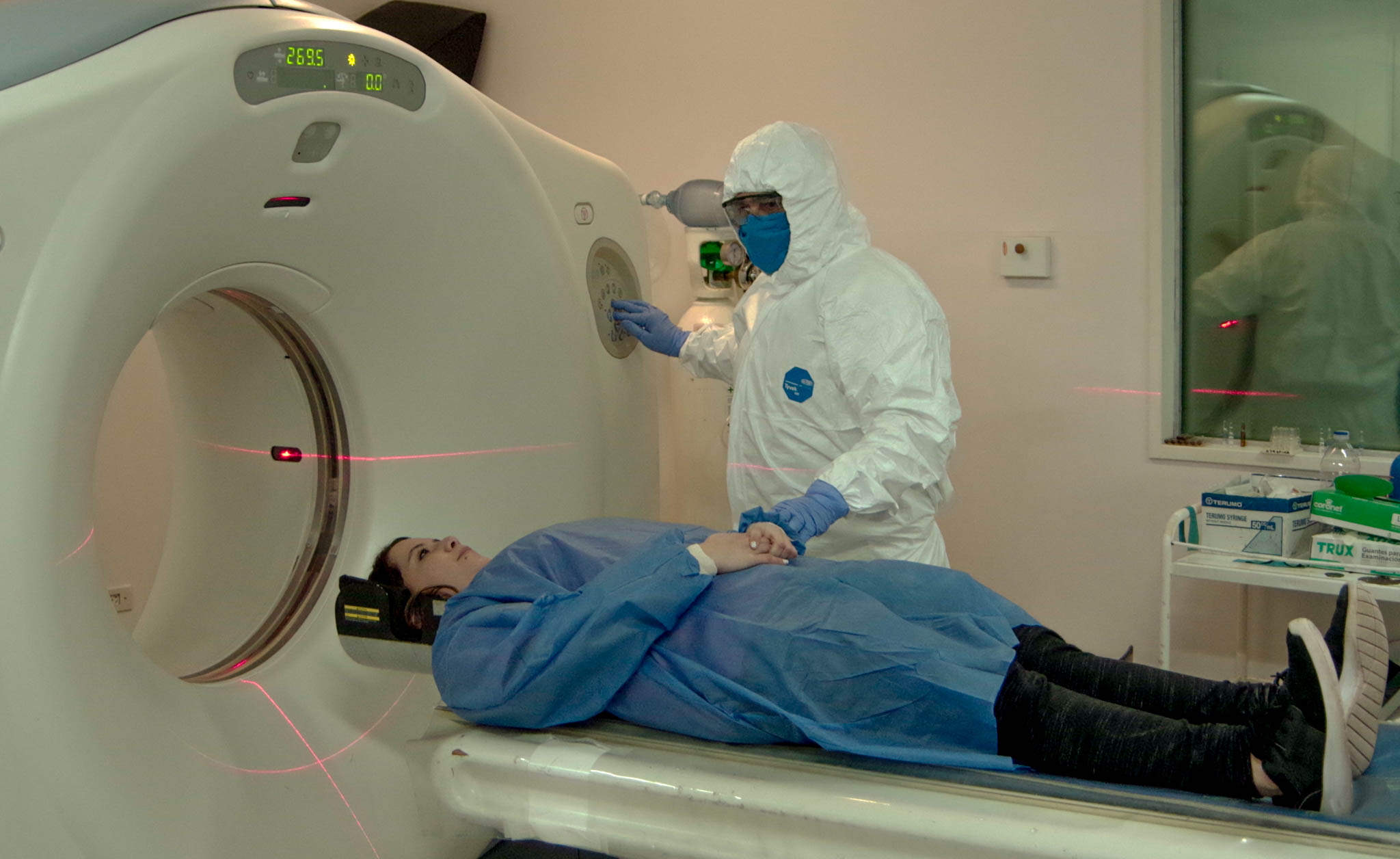 Paciente de sexo femenino y médico realizando tomografía con protocolo de bioseguridad